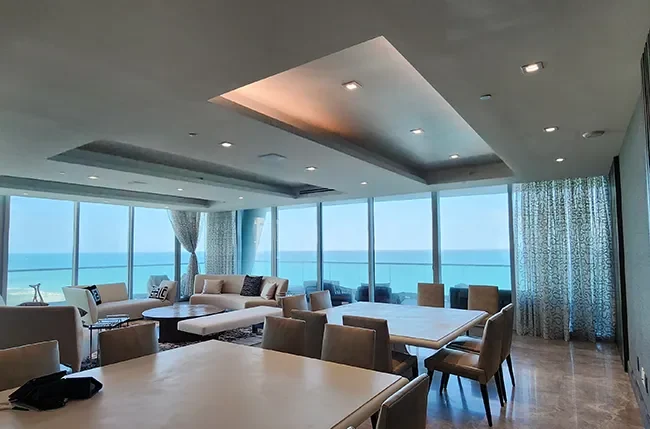 Remodeled coastal living room with recessed lighting and illuminated ceiling detail