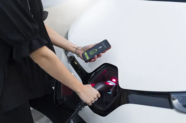 Electric vehicle plugged into a wall-mounted charging station