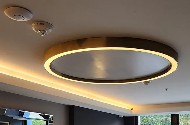 Circular illuminated ceiling feature with warm perimeter lighting