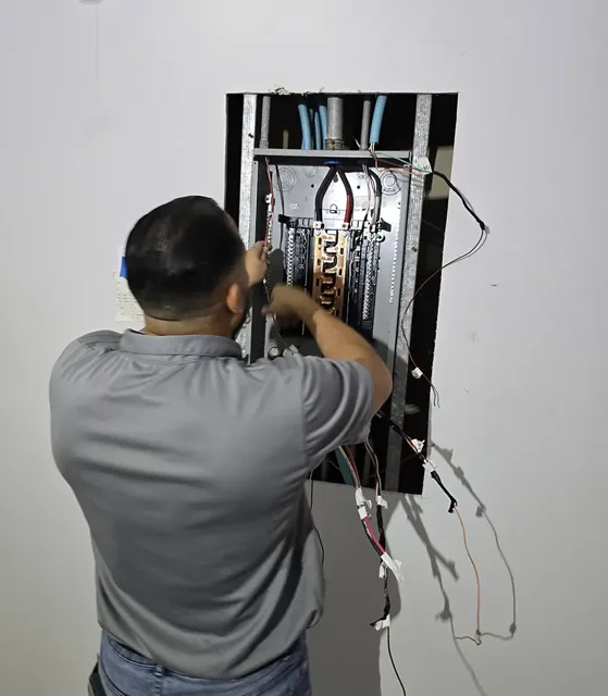 Technician working on wiring in an electrical panel